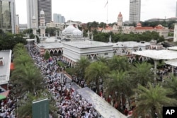 Protesters gather for a rally near a mosque to celebrate the government's decision not to ratify a U.N. anti-discrimination convention, in Kuala Lumpur, Malaysia, Dec. 8, 2018.