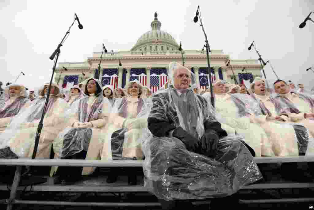 Thành viên ca đoàn Mormon Tabernacle Choir ngồi dưới mưa, chờ lễ tuyên thệ của tổng thống tân cử Donald Trump, bắt đầu tại Điện Capitol, Washington. 20 tháng Giêng. (AP Photo/Carolyn Kaster)