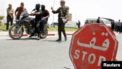 Un policier tunisien passe un point de contrôle à Kairouan, Tunisie, le 18 mai 2013.