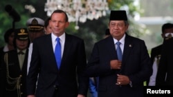 Australian Prime Minister Tony Abbott (L) walks beside Indonesian President Susilo Bambang Yudhoyono at the Presidential Palace in Jakarta, September 30, 2013. 
