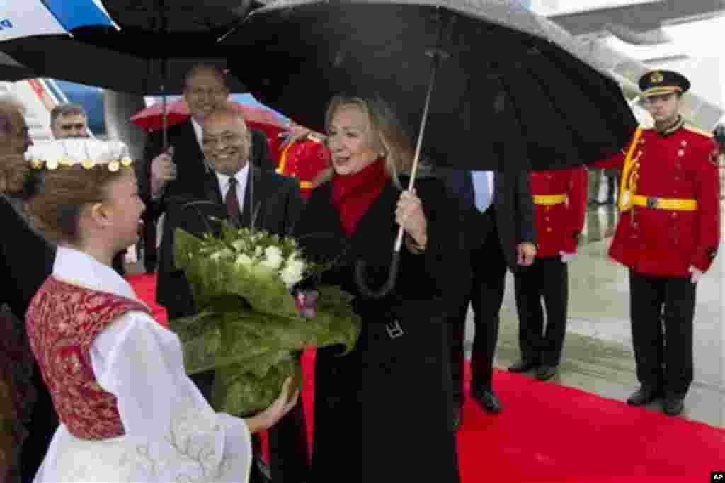 US Secretary of State Hillary Clinton receives flowers upon arrival at Tirana Rinas Airport in Tirana, Thursday, Nov. 1, 2012. Hillary Clinton arrived in EU-hopeful Albania on the last leg of her Balkans tour where she is expected to urge opposing politic