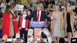 Republican presidential candidate Donald Trump , center, speaks with, from left, his wife, Melania, left, son Baron, and daughters Ivanka and Tiffany during a campaign rally in Myrtle Beach, South Carolina, Nov. 24, 2015.