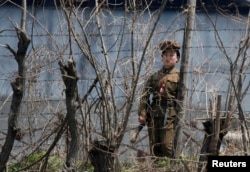 FILE - A North Korean prison policewoman stands guard behind fences at a jail on the banks of Yalu River near the Chongsong county of North Korea, opposite the Chinese border city of Dandong.