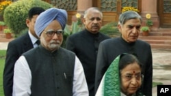 India's Prime Minister Manmohan Singh (in blue turban) and President Pratibha Patil arrive at the parliament on the first day of the budget session in New Delhi. The government will battle both inflation and corruption, February 21, 2011