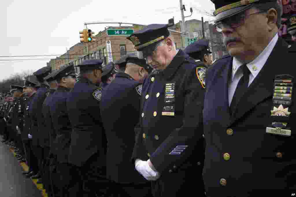 Some police officers turn their backs as Mayor Bill de Blasio speaks during the funeral of New York Police Department Officer Wenjian Liu at Aievoli Funeral Home in the Brooklyn borough of New York, Jan. 4, 2015.