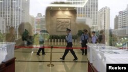 Police officers walk inside Hefei Intermediate People's Court, where the Gu Kailai trial will be held on Thursday, in Hefei, Anhui Province, August 8, 2012.