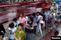 People wait in line to buy moon cakes, a Chinese traditional dish as part of the upcoming Mid-Autumn Festival in Shanghai, Sept. 5, 2014.