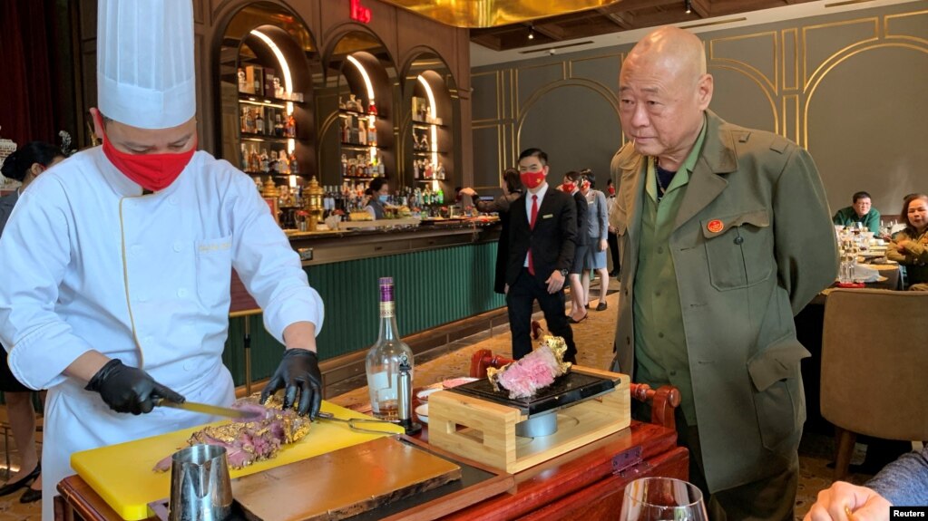 Một đầu bếp phục vụ món bít tết dát vàng cho một cựu chiến binh tại nhà hàng Dolce By Wyndham Hanoi Golden Lake ở Hà Nội, 4/12/2021.