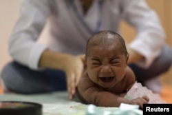 Pietro Rafael, who has microcephaly, reacts to stimulus during an evaluation session with a physiotherapist in Recife, Brazil, Jan. 28, 2016.