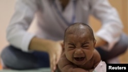巴西一名患有小脑畸形病症的婴孩在累西腓市一个康复中心接受医生的身体检查。 （2016年1月28日）