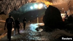 Rescue personnel walk in a cave at the Tham Luang cave complex during a mission to evacuate the remaining members of a soccer team trapped inside, in Chiang Rai, Thailand July 9, 2018, in this photo obtained from social media.