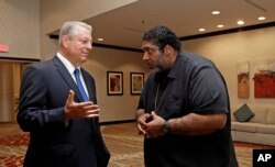 FILE - Former U.S. Vice President Al Gore, left, speaks with the Rev. Dr. William J. Barber II in Greensboro, N.C., Aug. 13, 2018.