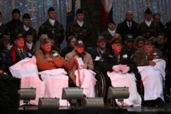 Anggota veteran AS dari pertempuran Bulge (barisan depan), mendengarkan pidato dalam upacara memperingati 75 tahun Pertempuran Bulge di Mardasson Memorial, Bastogne, Belgia, Senin, 16 Desember, 2019.
