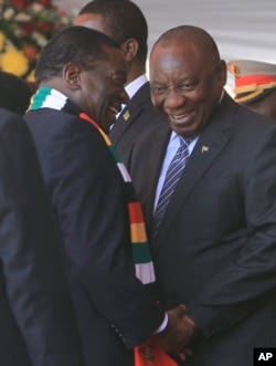 FILE: Zimbabwean President Emmerson Mnangagwa talks with South African President Cyrill Ramaphosa, right, during his inauguration ceremony at the National Sports Stadium in Harare, Sunday, Aug. 26, 2018.