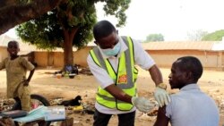 FILE - Yunusa Bawa, a community health worker, injects a man with AstraZeneca coronavirus vaccine in Sabon Kuje on the outskirts of Abuja, Nigeria, Dec 6, 2021.