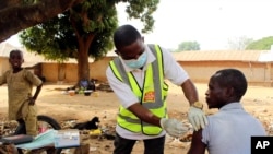 FILE - Yunusa Bawa, a community health worker, injects a man with AstraZeneca coronavirus vaccine in Sabon Kuje on the outskirts of Abuja, Nigeria, Dec 6, 2021.