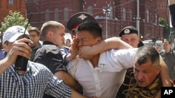 Policemen, some dressed in plain clothes, detain gay rights activist Daniel Choi, center, near the Kremlin during an unsanctioned gay pride parade in central Moscow, May 28, 2011