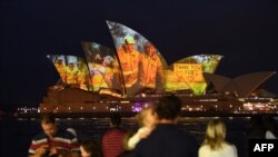 Nhà Hát Opera ở Sydney thắp sáng để hỗ trợ các cộng động bị tác động bởi nạn cháy rừng, và bày tỏ lòng biết ơn đói với các dịch vụ khẩn cấp tình nguyện ở Sydney. Ảnh chụp ngày 11/1/2020. (Photo by SAEED KHAN / AFP)