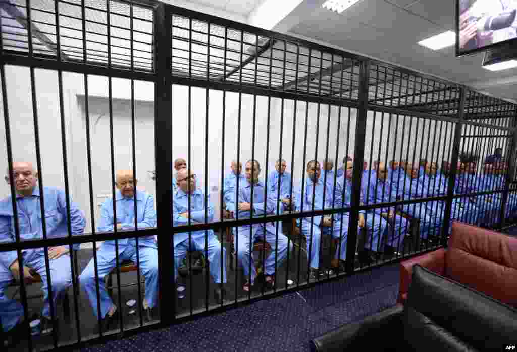Mantan staf diktator Libya Moammar Gadhafi duduk di balik sel terpidana selama pengadilan berlangsung di pengadilan banding di Tripoli. Pengadilan Libya menjatuhkan hukuman mati kepada anak dan delapan staf diktator Libya tersebut atas kejahatan yang mereka lakukan pada pemberontakan tahun 2011.