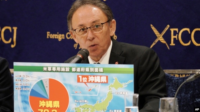 FILE - Okinawa Governor Denny Tamaki shows a chart on the U.S. military area in each prefecture in Japan during a press conference on March 1, 2019, in Tokyo.
