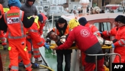 A rescued sailor is brought ashore in the harbor at Ravenna, Italy, Dec. 28, 2014. 