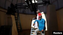 Devendran (right) and his father Paramasivan, pose for a photograph inside an observation dome at the Kodaikanal Solar Observatory, India, Feb. 6, 2017.