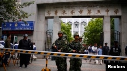 FILE - Paramilitary policemen stand guard in front of Urumqi No. 5 middle school after Thursday's attack in downtown Urumqi, Xinjiang, Uighur Autonomous Region.