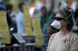 Seorang turis mengenakan masker di terminal kedatangan internasional Bandara I Gusti Ngurah Rai, Bali, 31 Januari 2020. (Foto: Reuters)