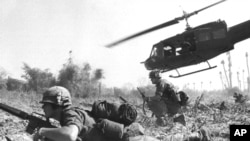 A U.S. helicopter climbs skyward after discharging a load of infantrymen in Vietnam.