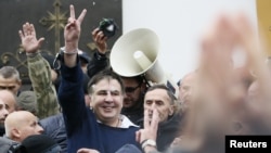 Georgian former President Mikheil Saakashvili flashes a victory sign after he was freed by his supporters in Kyiv, Ukraine, Dec. 5, 2017.