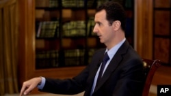 FILE - In this photo, which AP obtained from Syrian official news agency SANA President Bashar Assad gestures as he speaks during an interview on Oct. 21, 2013.