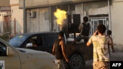 Un membre des forces loyales au Gouvernement libyen soutenu par les Nations Unies (GNA) tire une mitrailleuse près de la zone centrale appelée District One, dans la ville côtière de Syrte, à l'est de la capitale Tripoli, 21 août 2016.