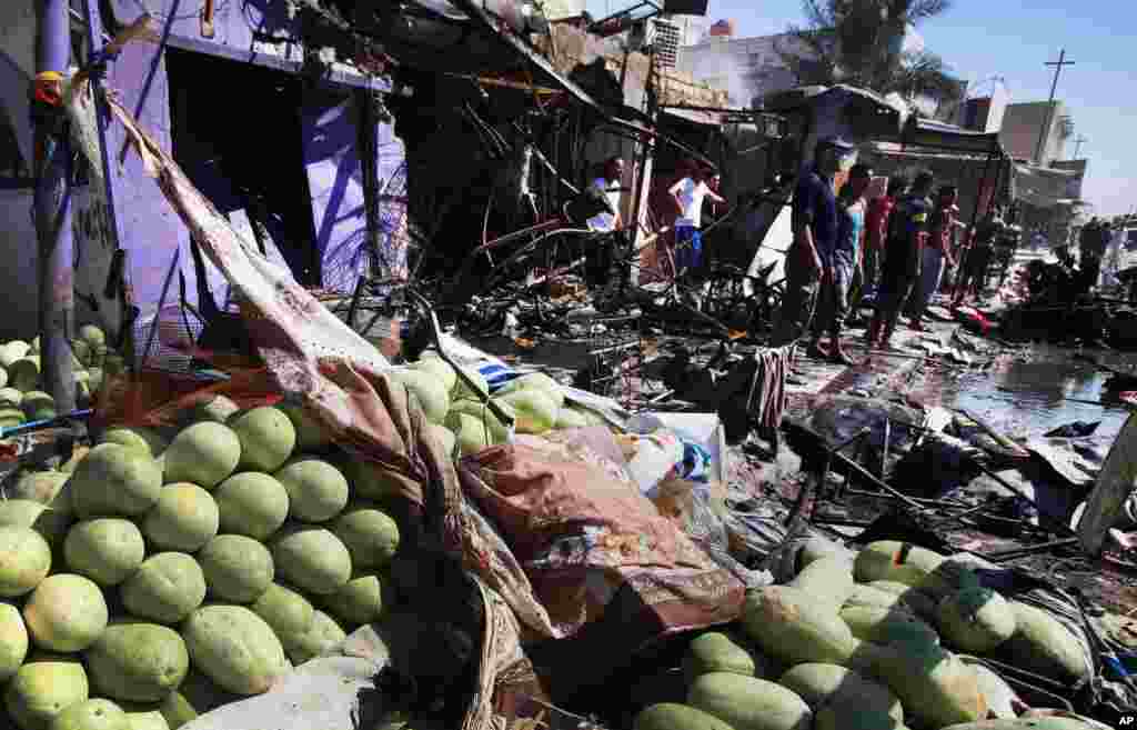 People inspect the site of a car bomb explosion in Basra, southeast of Baghdad, July 29, 2013.