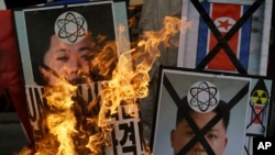 South Korean protesters burn the pictures of North Korean leader Kim Jong Un during an anti-North Korea rally following a nuclear test conducted by North Korea, in Seoul, South Korea, February 12, 2013. 