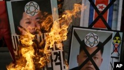 Người Hàn Quốc đốt hình ảnh lãnh tụ Bắc Triều Tiên Kim Jong Un trong cuộc biểu tình phản đối vụ thử hạt nhân của Bình Nhưỡng ở Seoul, ngày 12/2/2013. 