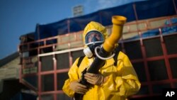 A health worker stands in the Sambadrome as he sprays insecticide to combat the Aedes aegypti mosquitoes that transmit the Zika virus, in Rio de Janeiro, Brazil, Jan. 26, 2016. 