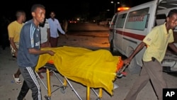 Rescuers remove a dead body from the scene of a car bomb attack close to the presidential palace in the capital Mogadishu, Somalia, Oct. 15, 2014.