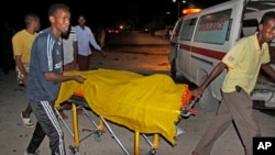 索馬里首都摩加迪沙發生兩宗汽車炸彈爆炸﹐救援人員正運送一名死者的屍體。