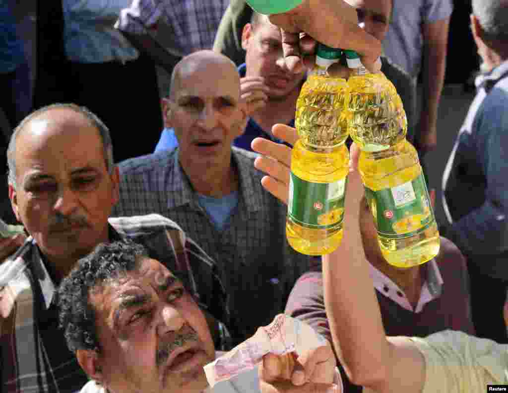 خرید و فروش روغن و دیگر محصولات یارانه ای از یک کامیون دولتی در قاهره مصر. بعد از سرازیر شدن ارزخارجی، توسط بانک مرکزی مصر، خیلی‌ از کالاهای فروشگاه‌های مواد غذایی کم شدند و باعث شدند که مردم مصر از دولت محصولات یارانه ای بخرند.