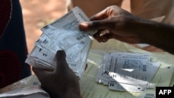 A worker holds voter registration cards during a distribution in Bangui, Central African Republic, ahead the country's presidential elections, Dec. 25, 2015.