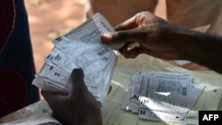 Distribution de bulletins de vote dans un bureau de vote à Bangui, Dec. 25, 2015.