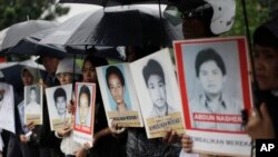 Para kerabat berdemo di luar Kedutaan Besar AS sambil membawa foto para aktivis yang hilang dan korban pelanggaran HAM yang diduga dilakukan oleh sejumlah anggota KOPASSUS pada 1997-1998, 27 Juli 2010. (Foto: Dita Alangkara/AP,arsip) 