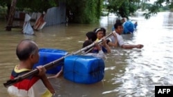 Cư dân tìm đủ mọi cách để lội qua dòng nước lũ ở tỉnh Nakhon Ratchasima, đông bắc Thái Lan, ngày 17/10/2010