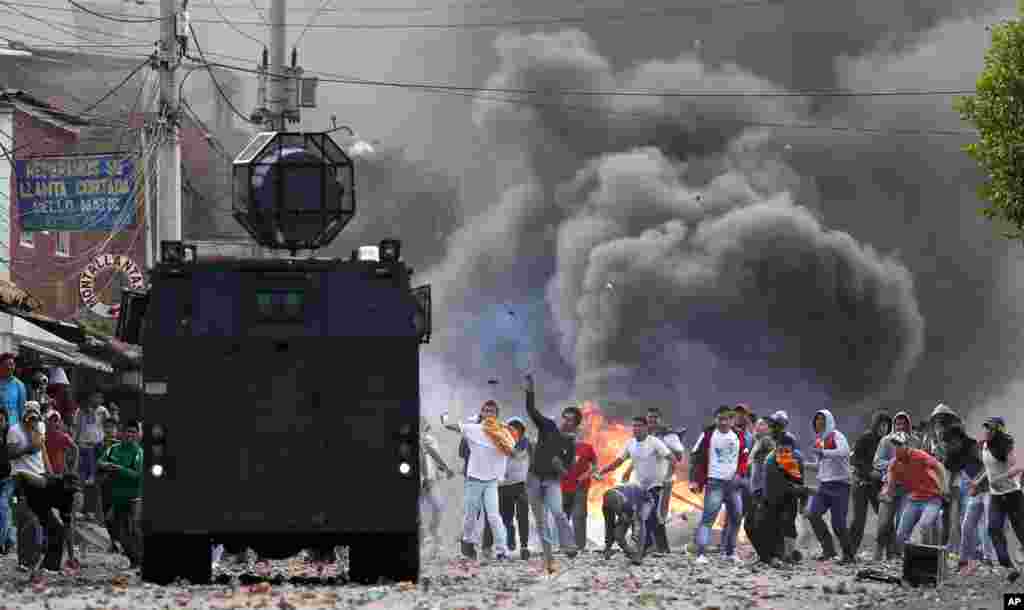 Protesters throw stones at a police vehicle in Ubate, north of Bogota, Colombia, Aug. 26, 2013. Hundreds of protesters clashed with police in support of farmers who had being blockading highways for a week for an assortment of demands that include reduced gasoline prices, increased subsidies and the cancellation of free trade agreements.