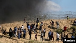 Manifestants palestiniens lapidant des soldats israéliens après des protestations contre le blocus de la bande de Gaza, à la frontière entre ce territoire et Israel, le 19 mai 2017. 