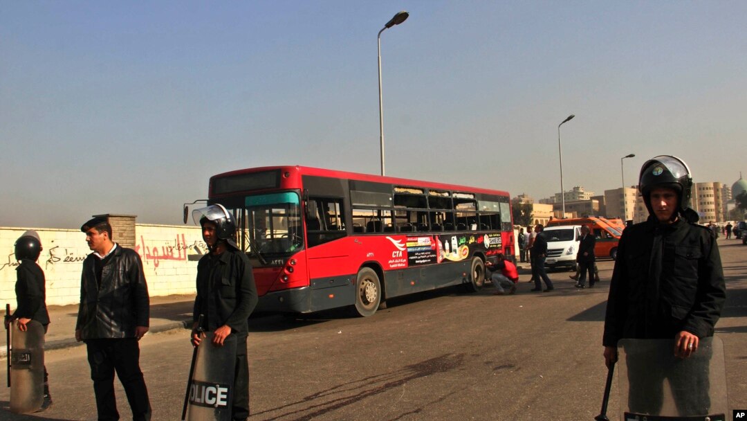 Egyptian police stand guard after an explosion has hit a public bus in Cairo's eastern Nasr City district, Dec. 26, 2013.