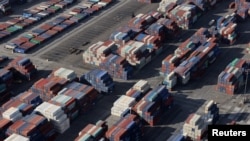 FILE - Shipping containers sit on the dock at a container terminal at the Port of Long Beach-Port of Los Angeles complex, in Los Angeles, California, April 7, 2021.