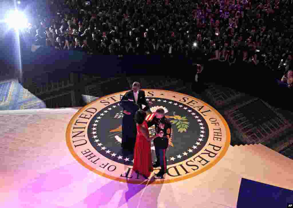 Presiden Barack Obama berdansa dengan staf Angkatan Udara Sersan Bria Nelson sementara ibu negaraMichelle Obama bersama penembak jitu Korps Marinir AS Sersan Timother Easterling pada pesta dansa inaugurasi Komandan Tertinggi Militer di Washington (21/1).