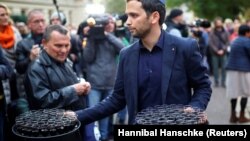 Seorang anggota komunitas Yahudi Halle membagikan minuman di luar sinagoga di Halle, Jerman 11 Oktober 2019, setelah dua orang tewas dalam penembakan. (Foto: REUTERS/Hannibal Hanschke)