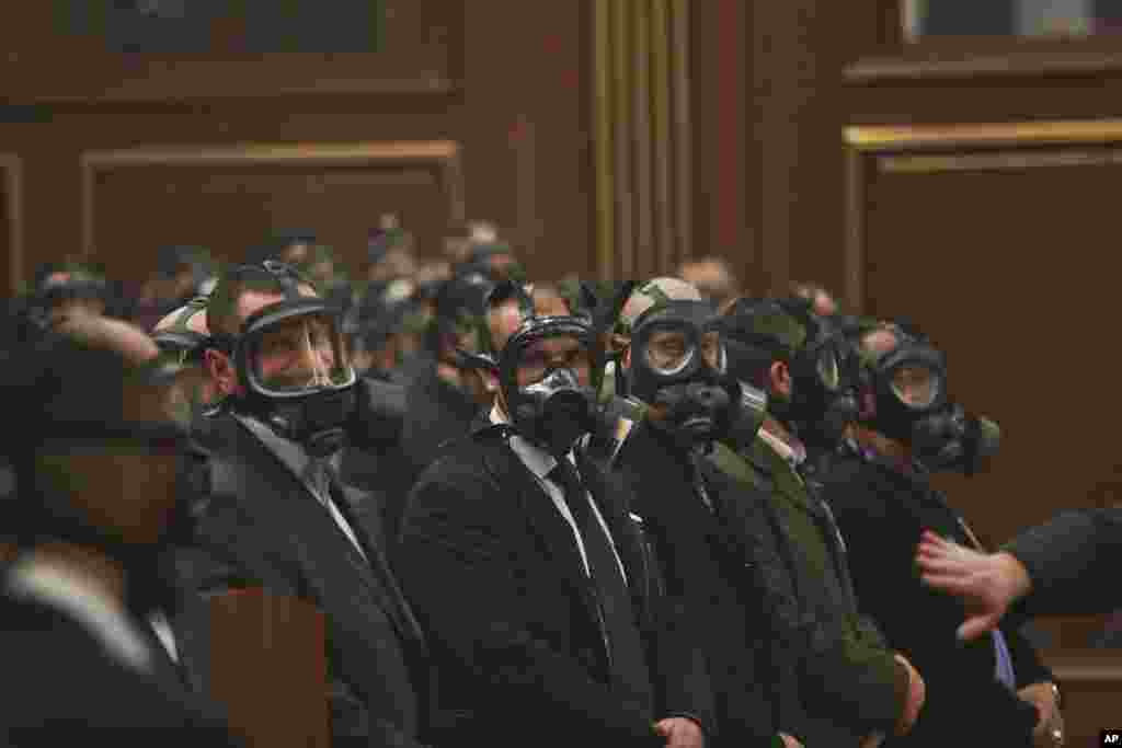 Security forces wear gas masks at the Kosovo assembly, after opposition lawmakers released tear gas canisters disrupting a parliamentary session in Pristina. Lawmakers were readying to vote on whether to elect Hashim Thaci, foreign minister and former guerrilla leader, as the next president.